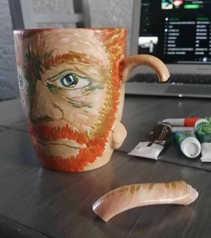 Taza pintada con rostro triste y asa rota, imagen realmente incómoda y divertida en cierto modo.