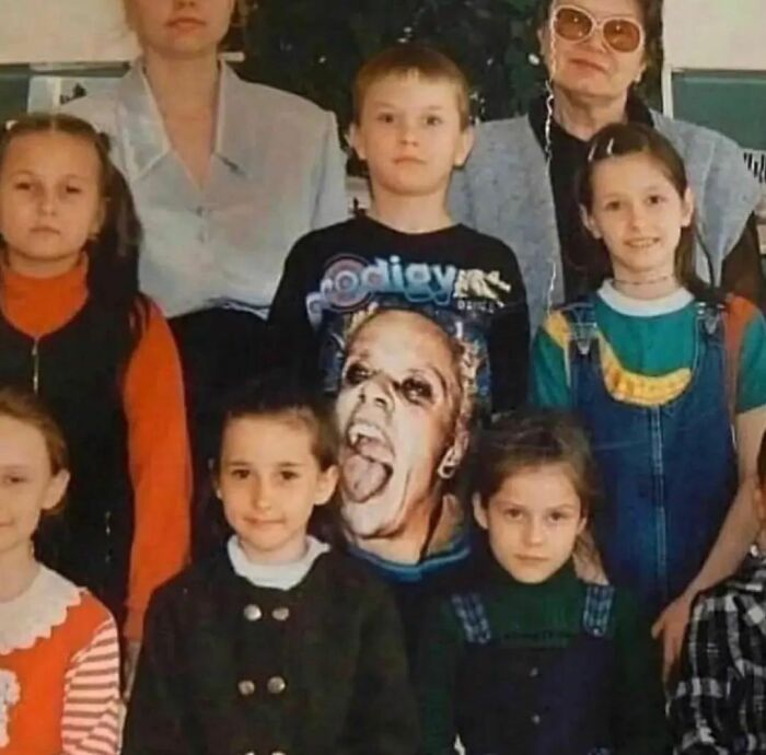 Niños y adultos en foto grupal con camiseta de rostro extraño que genera imagen realmente incómoda y divertida.