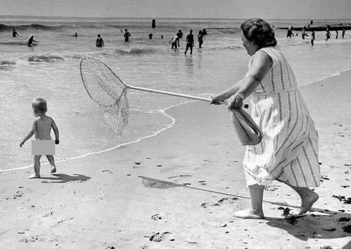 Mujer atrapando a un niño con una red en la playa Rockaway, 1958. Foto de Ed Clarity