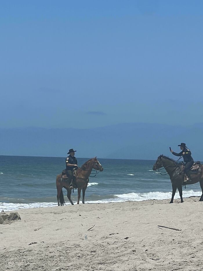 La policía montada haciéndose fotos en la playa