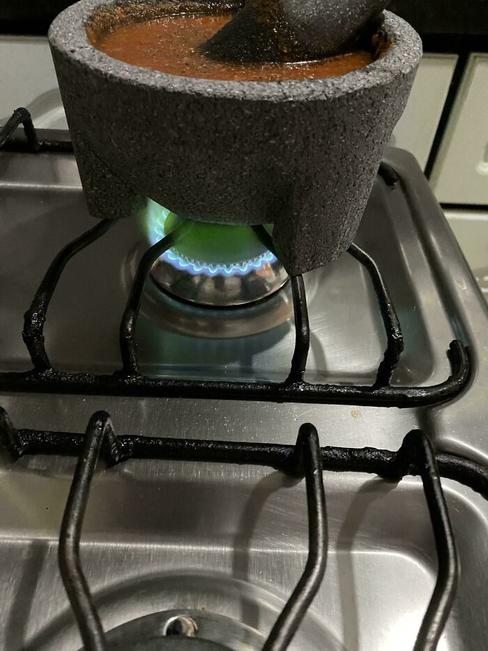 Mi madre está haciendo salsa con un mortero hecho de roca volcánica y la llama de la cocina se ha vuelto verde