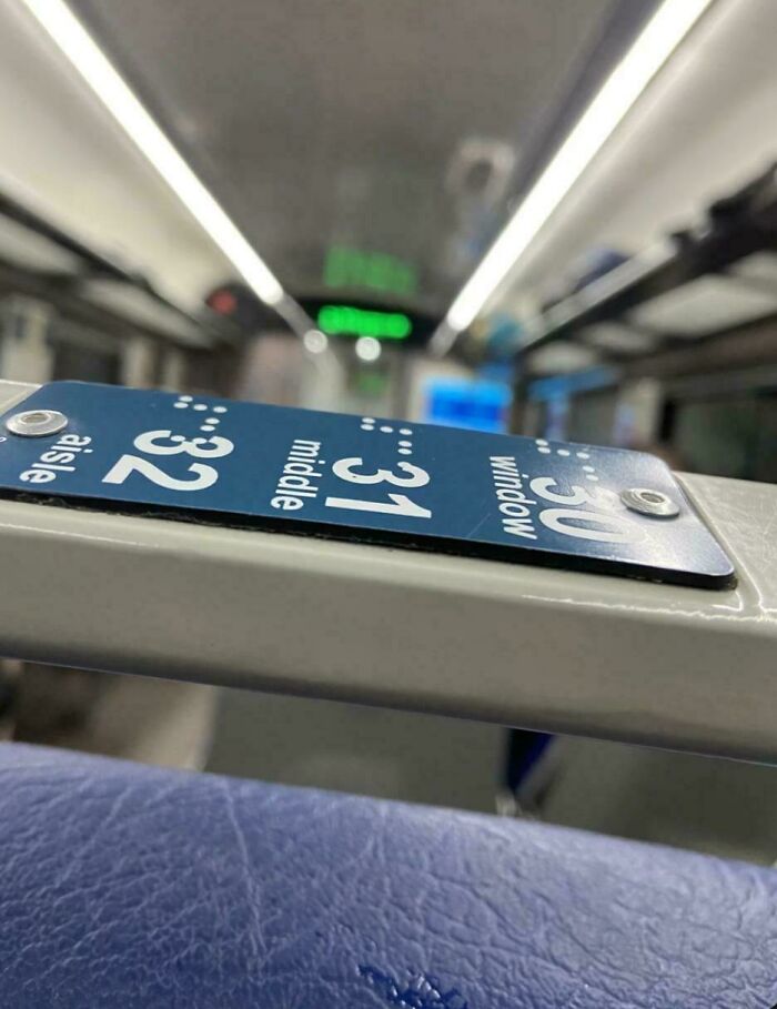Señal de asientos en transporte público con fallos evidentes que muestran la palabra middle mal colocada, ejemplo de fails.