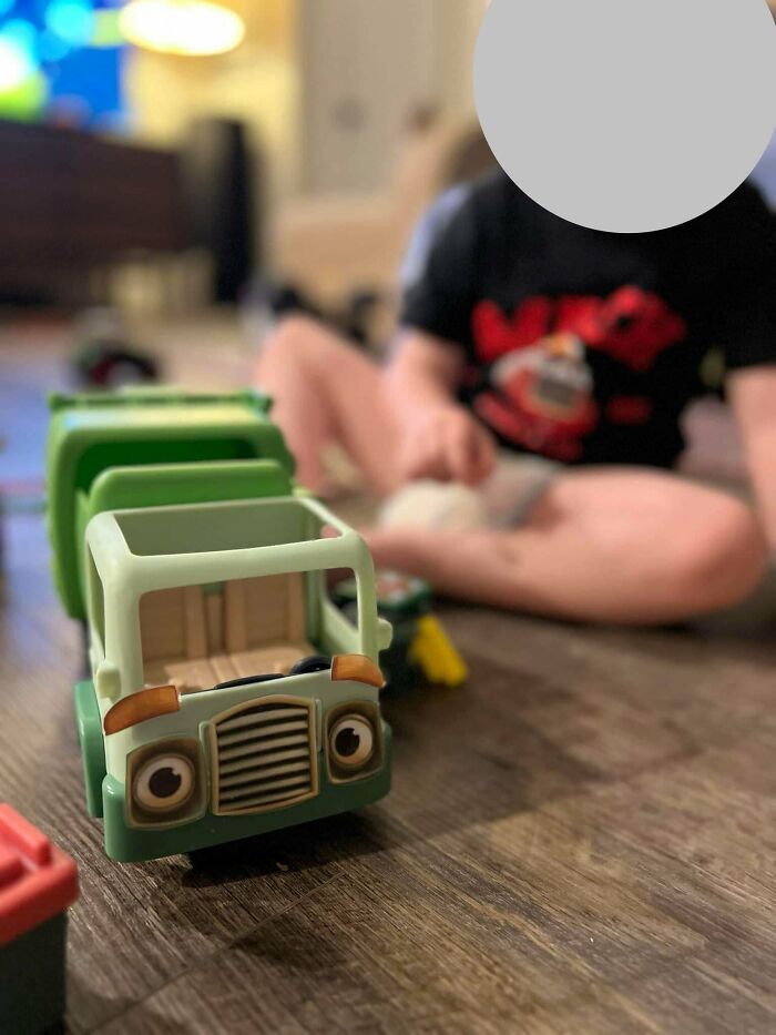 Niño jugando con camiones de juguete en casa, mostrando momentos divertidos y conmovedores de paternidad.