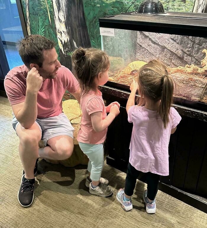 Padre mostrando momentos divertidos y tiernos con sus hijas mientras observan animales en un acuario.
