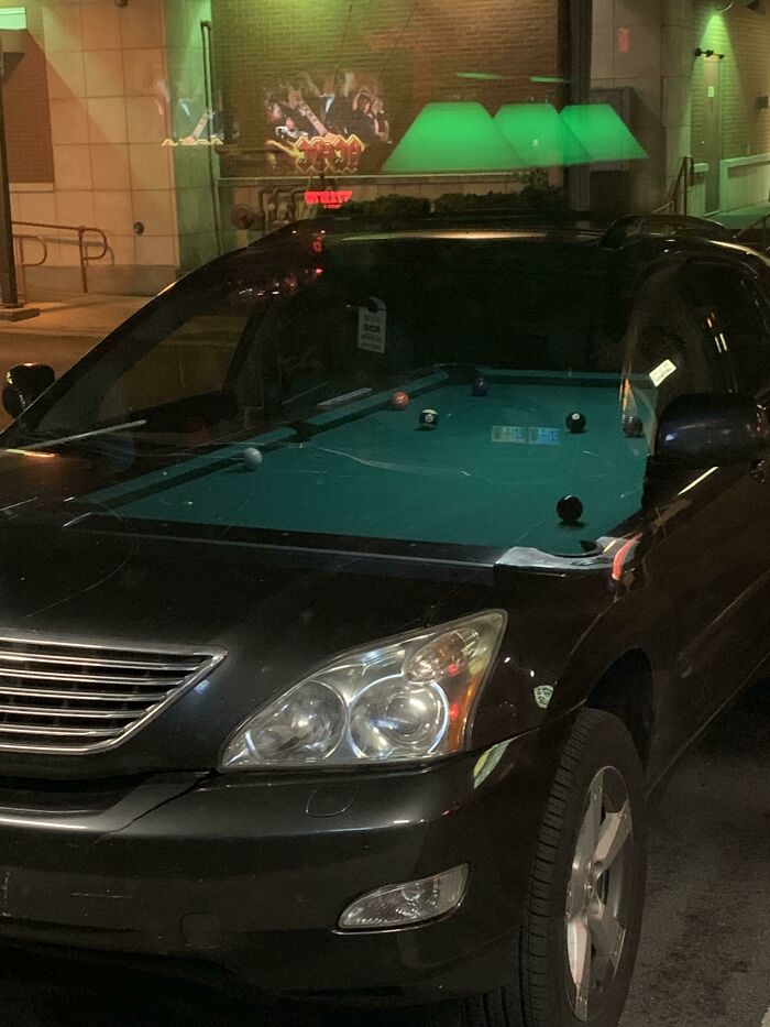El reflejo de la mesa de billar en este bar encajaba perfectamente con el interior del coche que estaba fuera