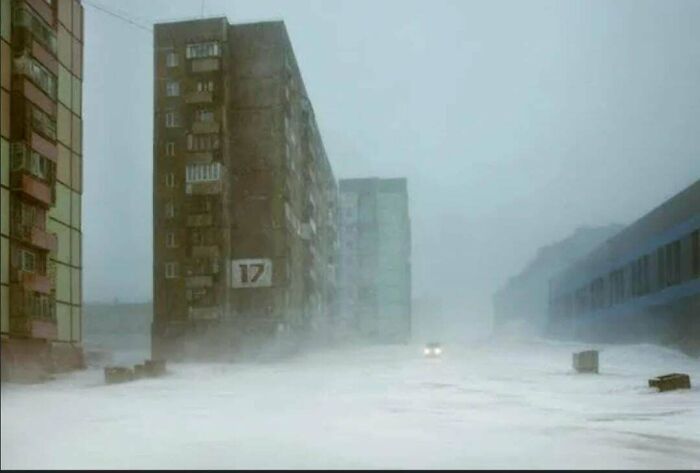 Edificios altos en área urbana desolada bajo clima extremo, ilustrando el infierno urbano.