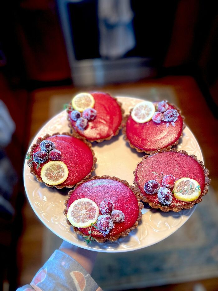 Tartaletas de repostería decoradas con frutos rojos y rodajas de limón, mostrando creatividad en postres.