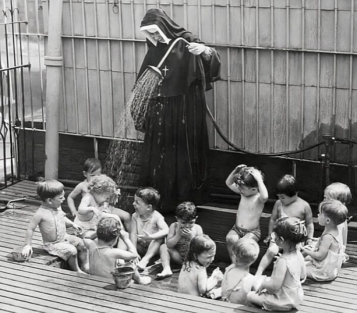 Una monja mantiene frescos a sus pequeños pupilos en la guardería Madonna House, Nueva York, verano de 1941.