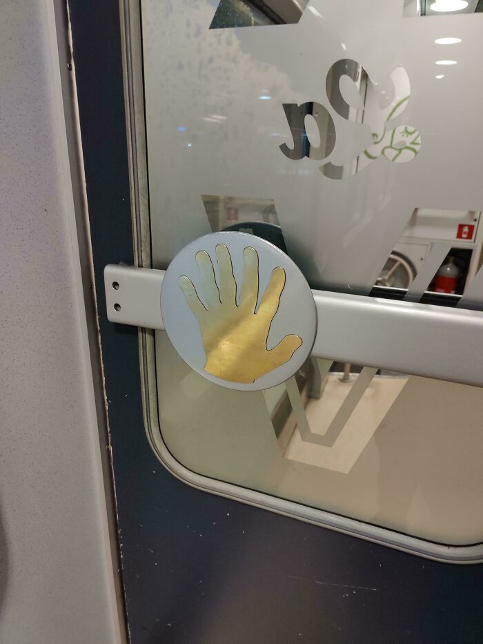 Mano dorada decorativa en cerradura de un autobús, claramente un fallo visible para quienes lo notan.
