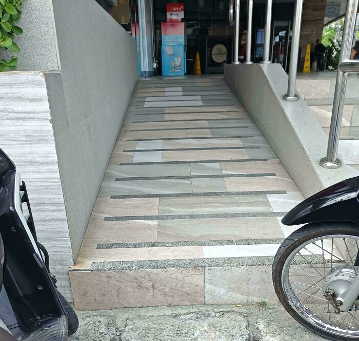 Rampas mal diseñadas con escalón al inicio, ejemplo de fallas patéticas en construcción urbana documentadas.