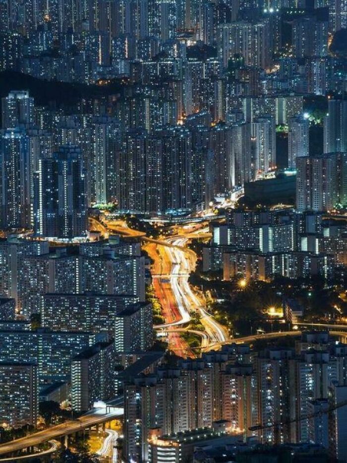 Vista nocturna de una densa ciudad con numerosos edificios altos y calles iluminadas, ejemplo de "infierno urbano".