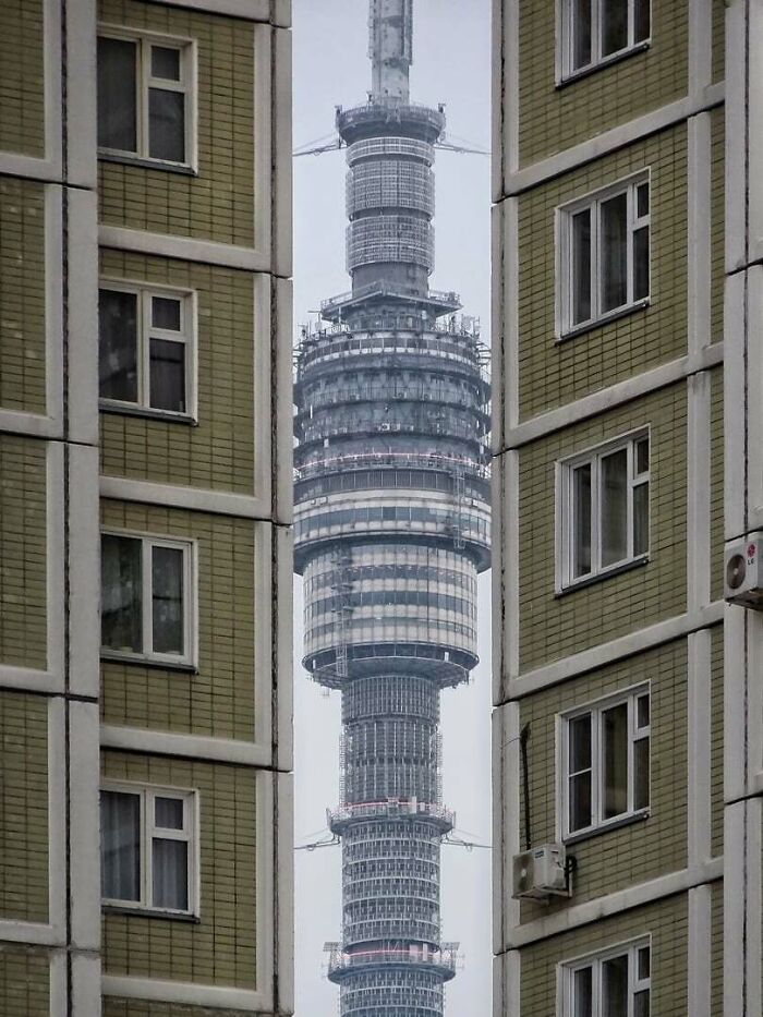 Torre urbana vista entre edificios, ejemplo de infierno urbano moderno.