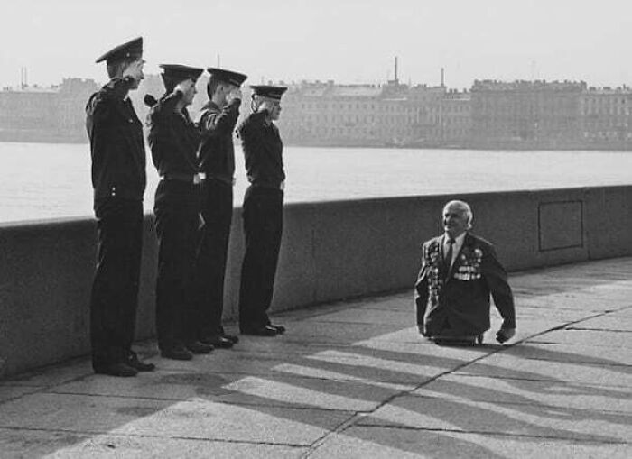 Anatoly Golimbievsky, un veterano soviético muy condecorado que perdió ambas piernas en la Segunda Guerra Mundial, agradece el saludo de cuatro jóvenes marineros de la Escuela Naval Nakhimov el Día V en Leningrado en 1989.