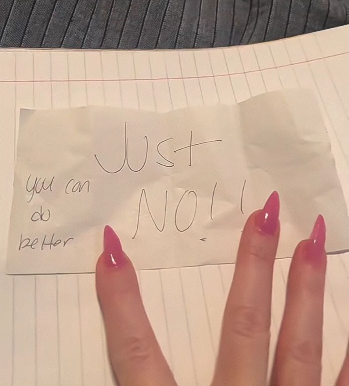 A woman's hand holding a note saying 