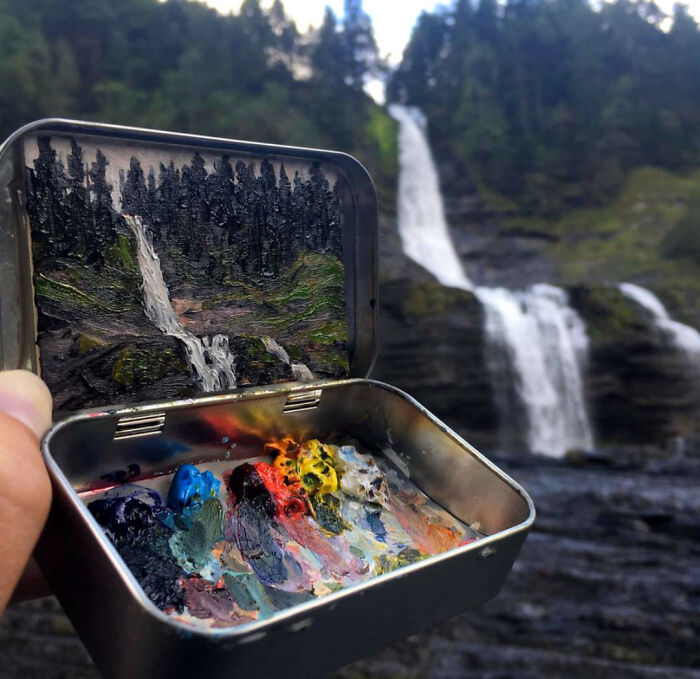 Caja metálica con pintura que recrea un paisaje de cascada y bosque, mostrando imágenes sorprendentes y surrealistas.