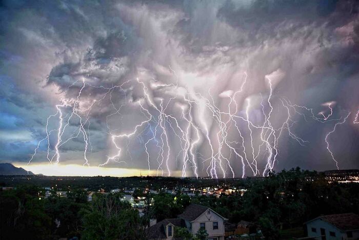 Tormenta eléctrica con múltiples rayos iluminando el cielo, imagen sorprendente con un toque de surrealismo sobre la ciudad.