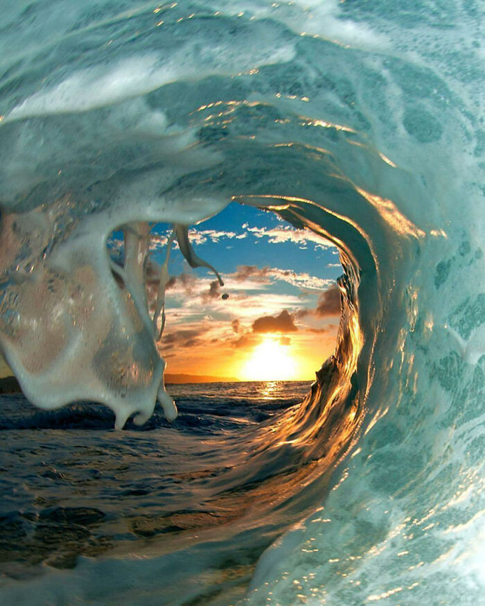 Ola de océano capturada en movimiento con un toque de surrealismo durante una puesta de sol vibrante.