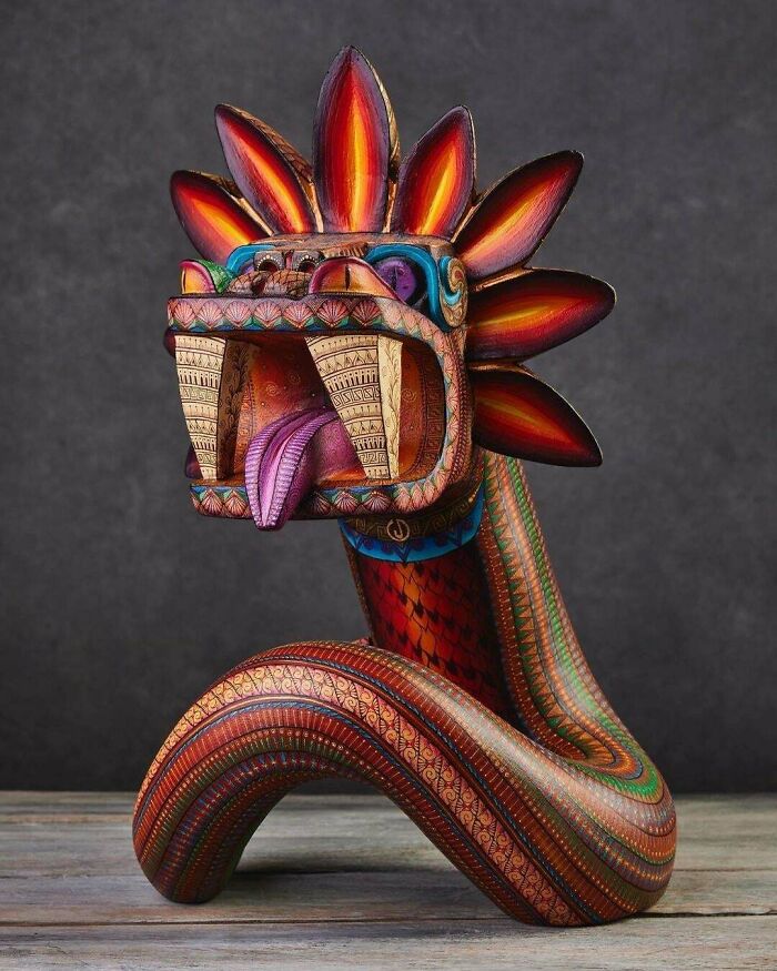 Escultura colorida de serpiente con detalles surrealistas y diseño artístico que refleja un toque de surrealismo vibrante.
