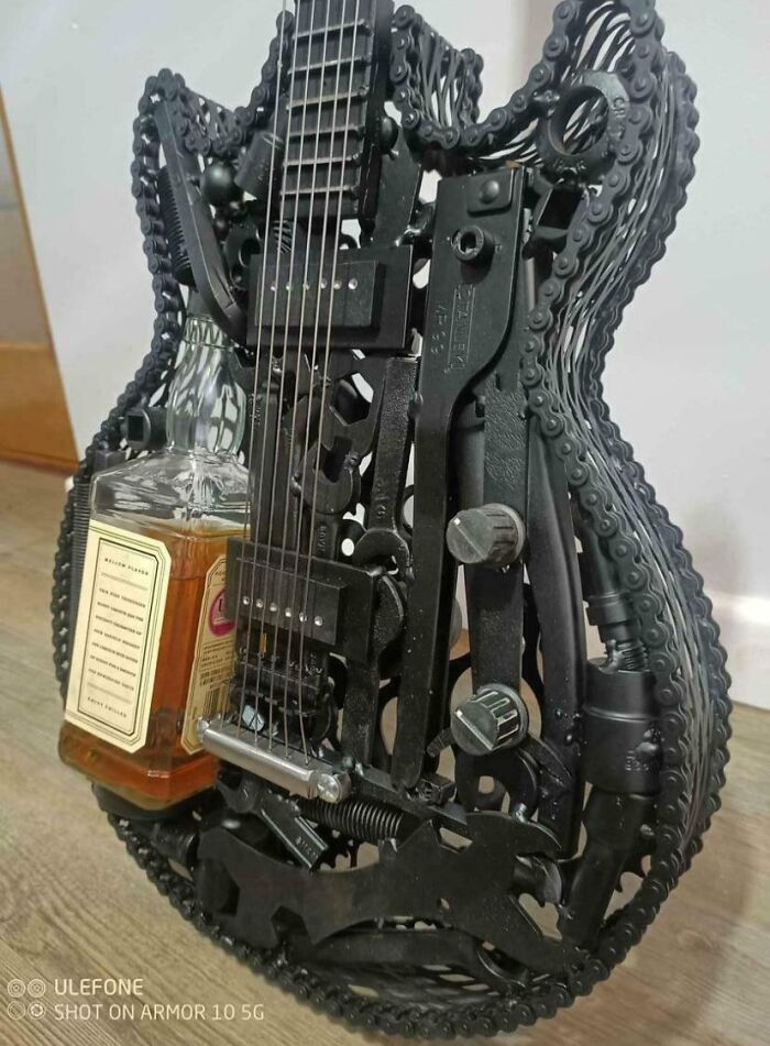 Guitarra eléctrica hecha de piezas de bicicleta que alberga una botella de Jack Daniels