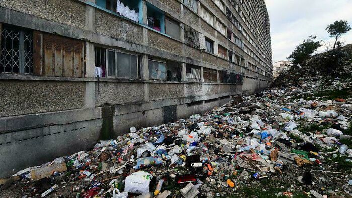 Edificio urbano rodeado de basura, ejemplo del «infierno urbano» moderno.