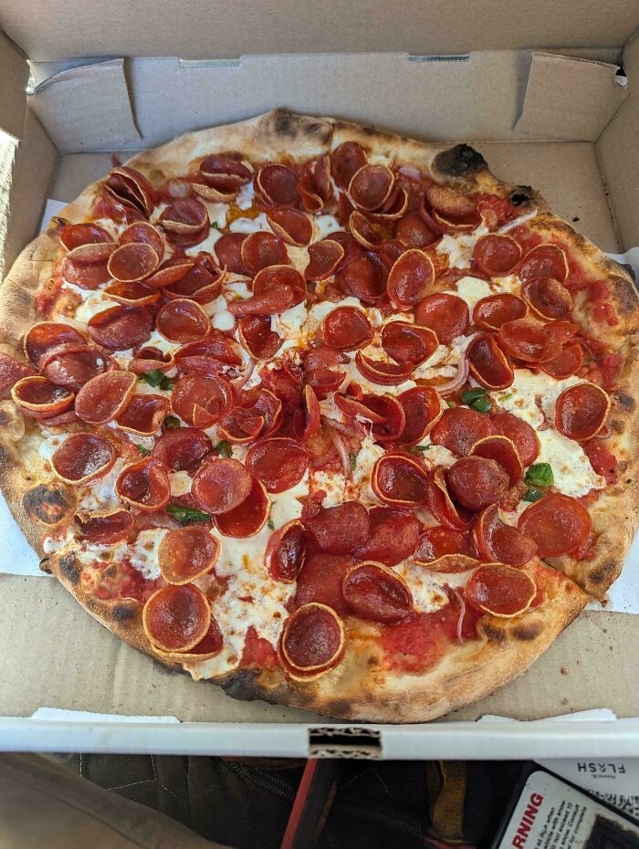 Pizza de pepperoni con abundante queso y salsa en caja de cartón, persona feliz con su pedido exacto.