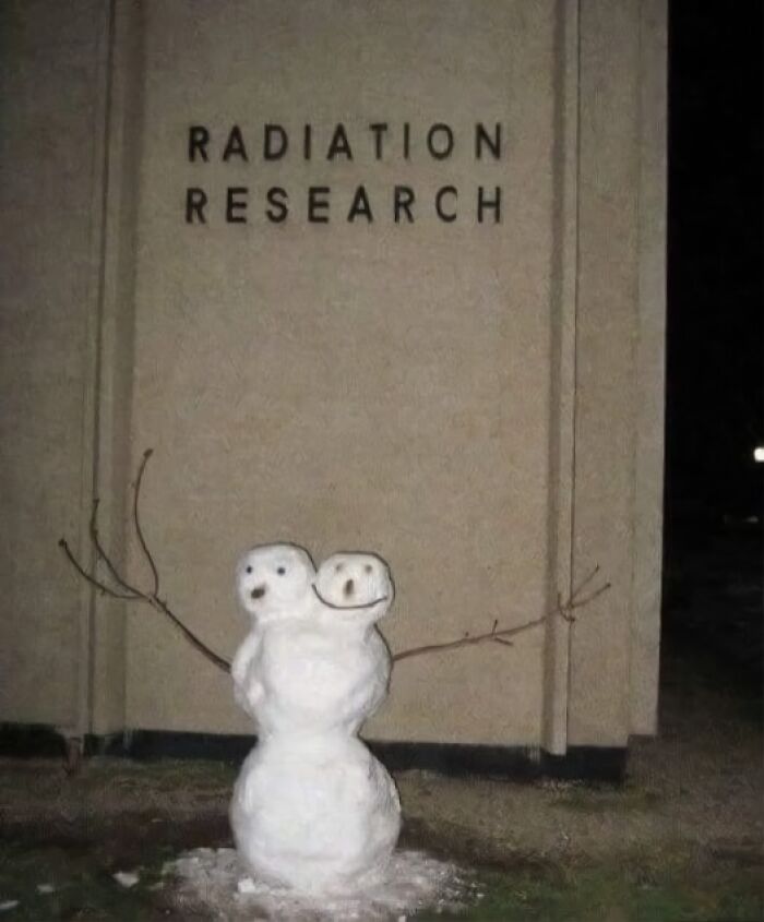 Muñeco de nieve con dos caras frente a edificio de investigación de radiación, divertido meme sobre ciencia para aprender y reír.