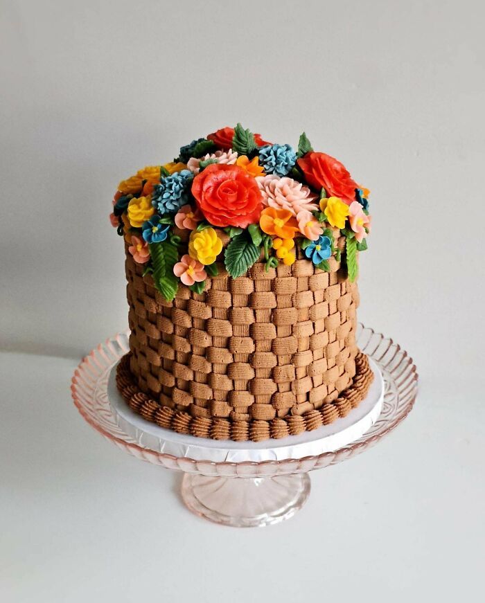 Pastel con decoración de flores de crema y diseño de repostería elaborado a otro nivel sobre base transparente.