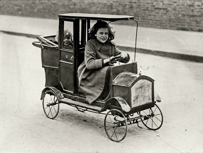 Niña en su coche a pedales, 1922 aprox.