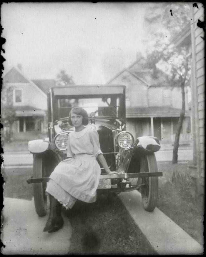 Una chica posando en un coche, hacia 1920
