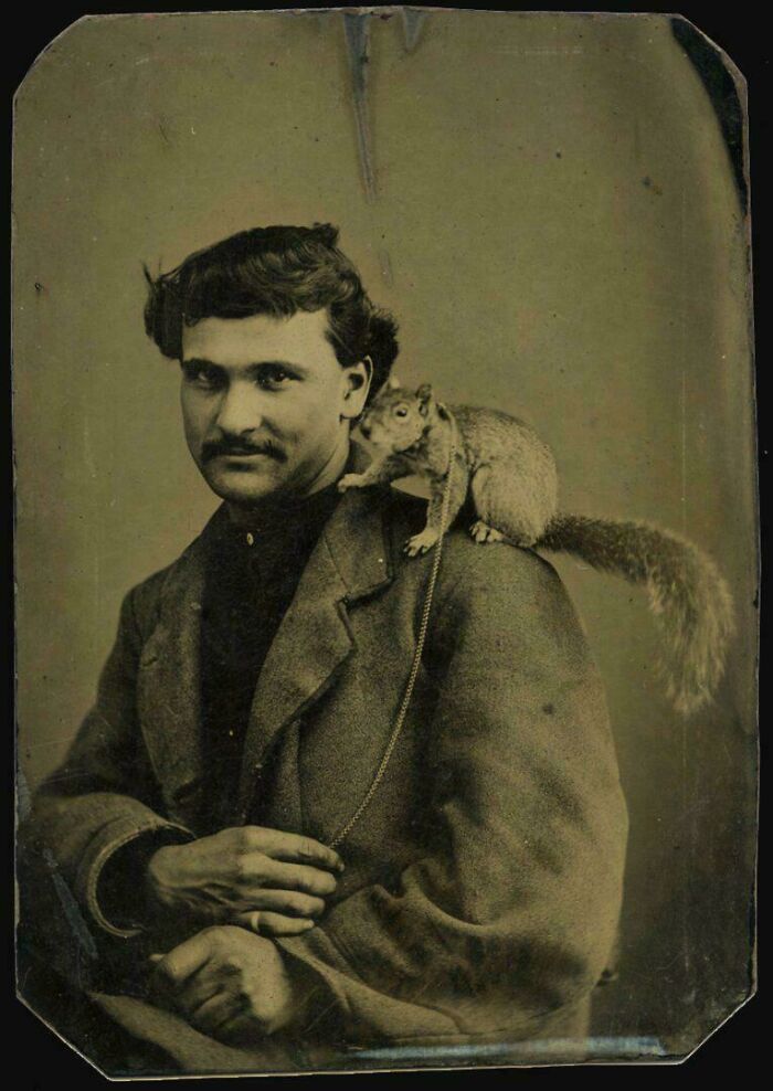 Hombre victoriano con ardilla en el hombro en una fotografía antigua de la época victoriana histórica.