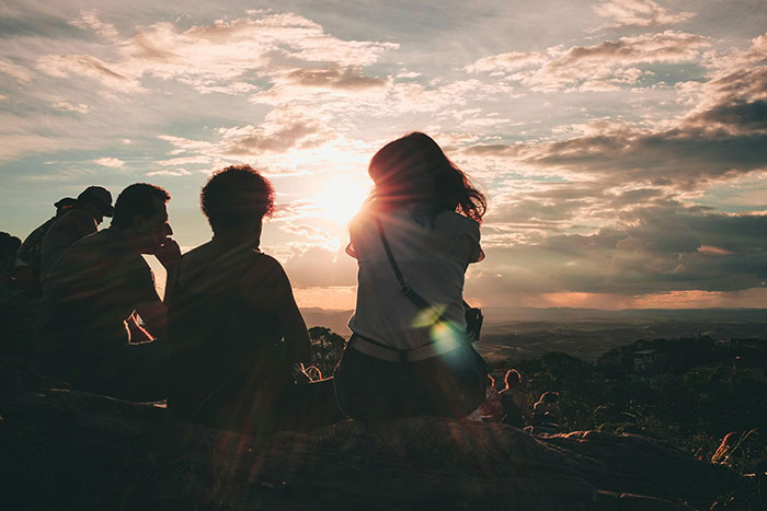 Personas contemplando el atardecer en grupo, disfrutando del juego de la vida con códigos de trucos efectivos.