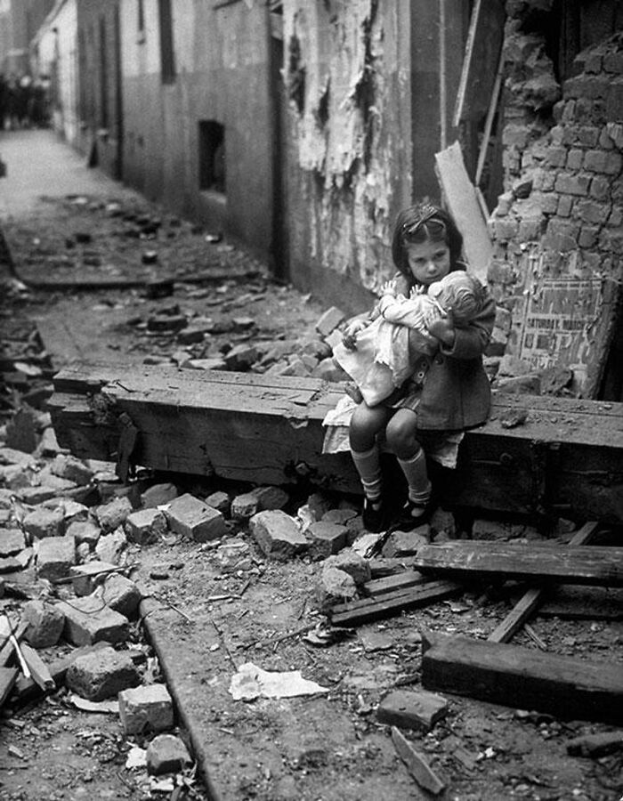Londres, 1940, una niña sentada con su muñeca entre los escombros de su casa bombardeada