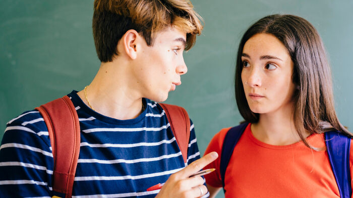 Joven discutiendo con seriedad frente a una pizarra, representando estupideces que la gente dijo con toda seriedad.