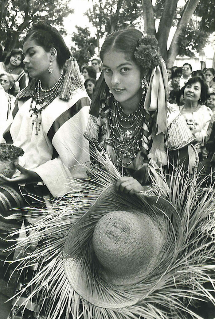 En medio de una celebración, una joven de Oaxaca, México, se da cuenta de que la están fotografiando y dirige una mirada a la cámara, 1985