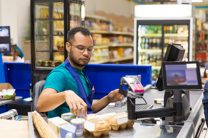 Empleado de supermercado organizando productos en caja, ejemplo de situaciones y estupideces que la gente dijo con seriedad.