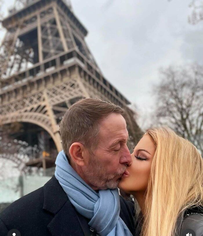 Pareja besándose frente a la Torre Eiffel, ilustrando la realidad versus Instagram.