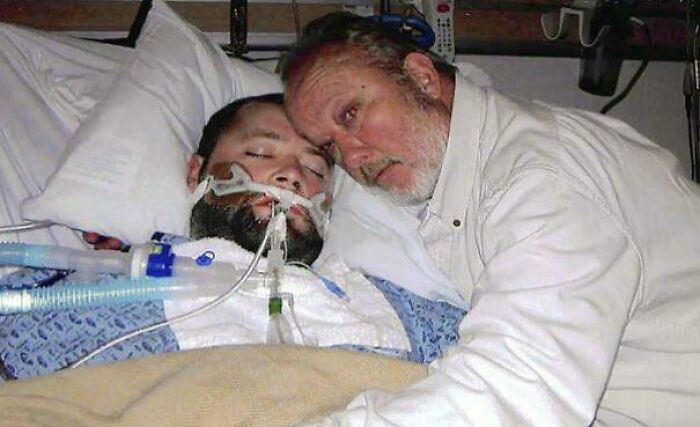 Hombres emocionados en un hospital, uno de ellos en cama con soporte vital, casi increíble conexión emocional.