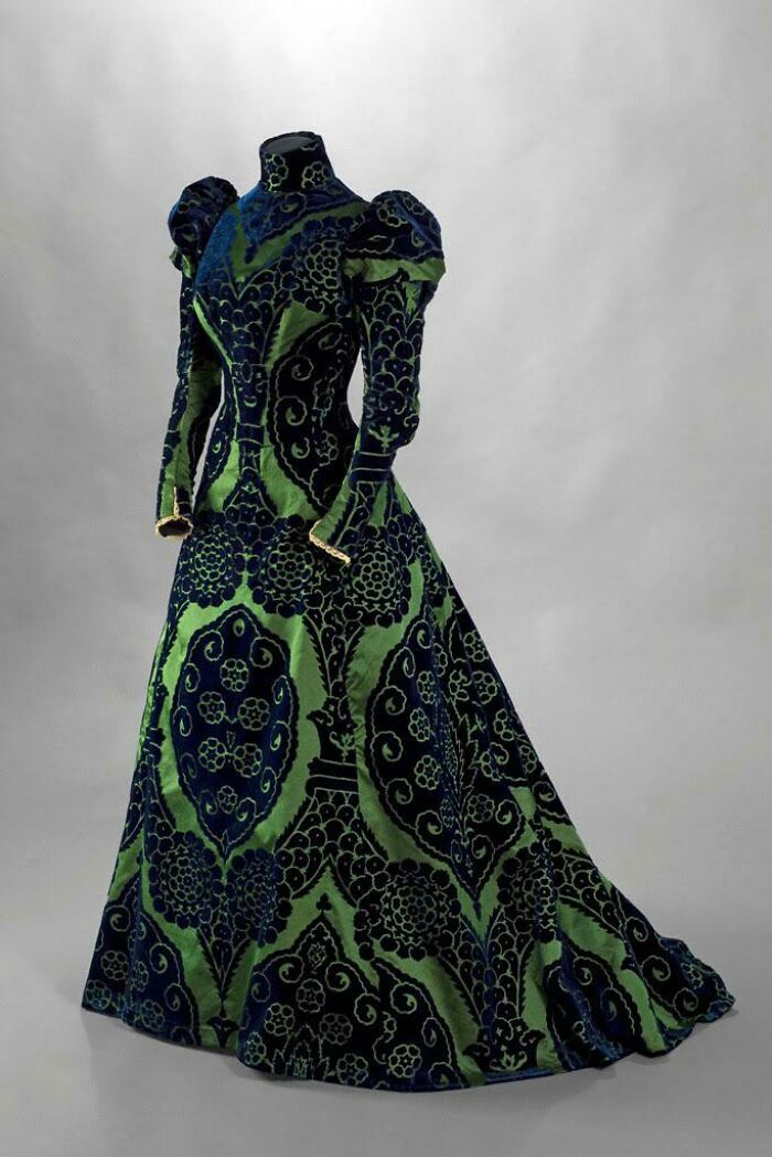 Vestido vintage verde y azul con detalles intrincados, ejemplo de un fascinante hallazgo del pasado lejano.