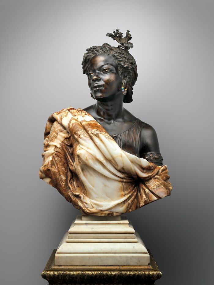 Escultura antigua detallada de busto femenino con vestimenta drapeada, reflejando el pasado lejano.
