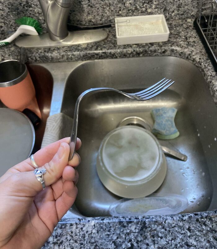 Tenedor doblado en un fregadero de cocina como ejemplo de hombres.