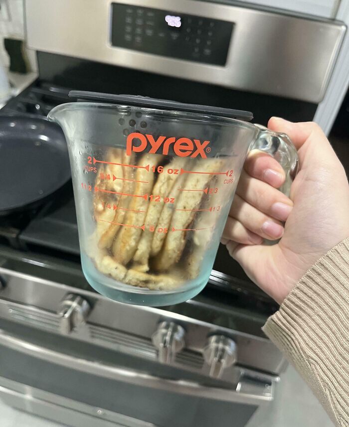 Taza medidora de Pyrex con galletas en una cocina, ejemplo humorístico de comportamiento masculino.