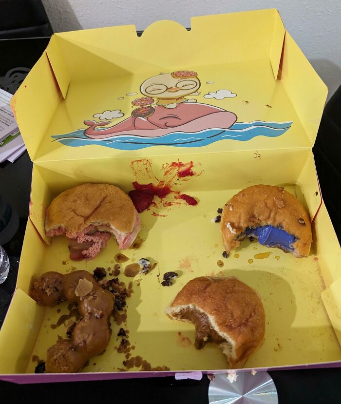 Caja amarilla de donas medio comidas, ejemplo divertido de novios y maridos comportándose como 
