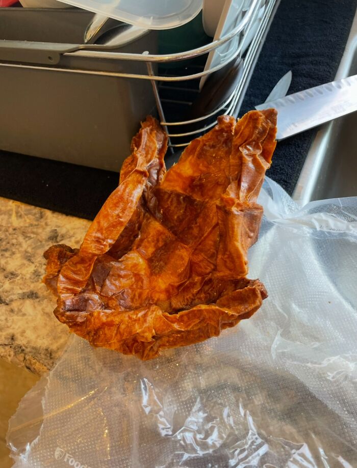 Un trozo de pollo cocido, aparentemente olvidado, sobre una superficie de cocina.