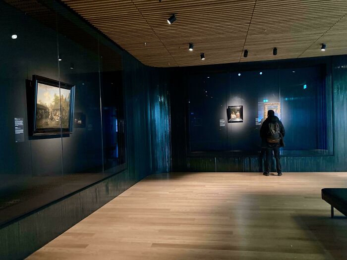 Visitante sorprendido en museo moderno contemplando obras de arte, experiencia única para viajeros en otros países.