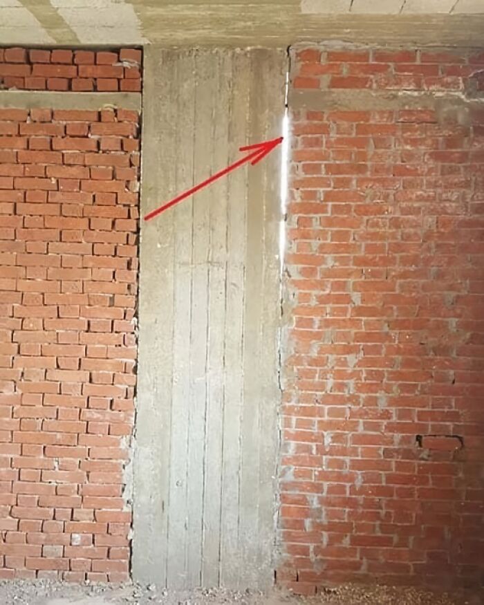 Fallo de arquitectura, pared de ladrillos mal alineada con hueco visible señalizado por una flecha roja.