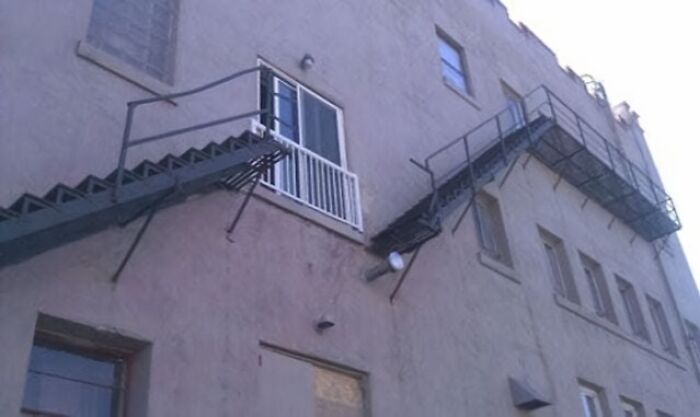 Escalera mal diseñada en la fachada de un edificio, mostrando un fallo de arquitectura gracioso.