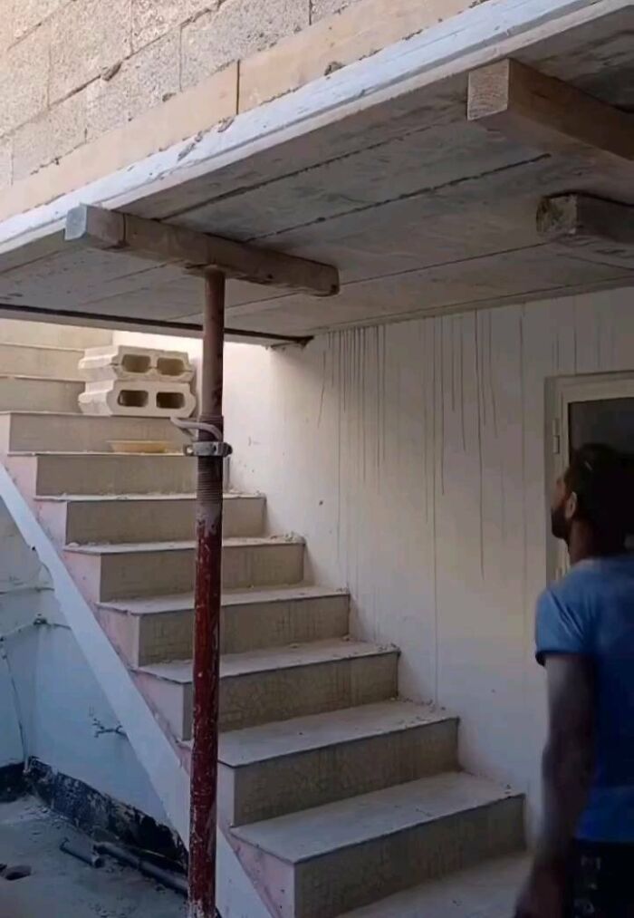 Escalera con diseño fallido, bloqueada por un techo mal construido, mostrando un error gracioso de arquitectura.