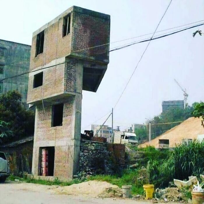Edificio inestable con diseño arquitectónico curioso en un entorno urbano.