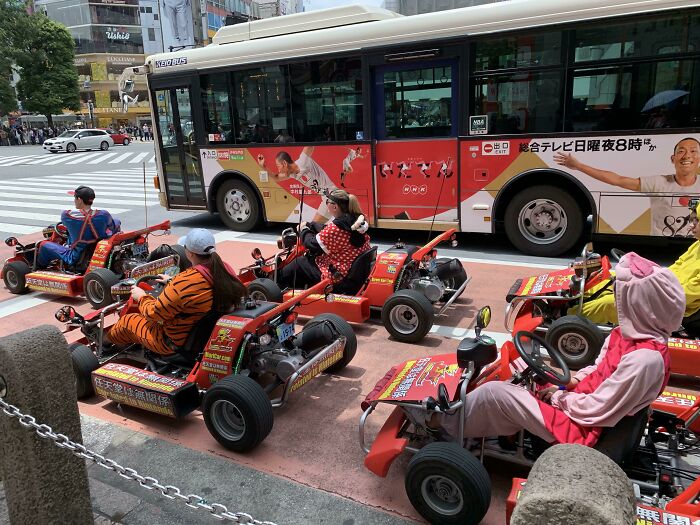 Grupo de viajeros en karts disfrazados en una ciudad extranjera, una de las cosas que sorprendieron a los viajeros en otros países.