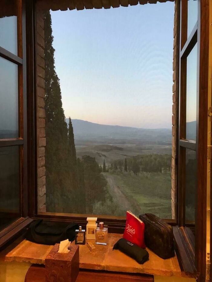Ventana abierta con vista a paisaje rural y objetos personales mostrando cosas que sorprendieron a los viajeros en otros países.